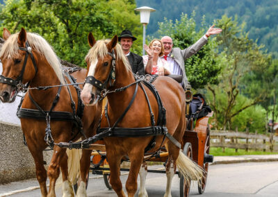 Hochzeit in Kreuth mit Kutsche winkend